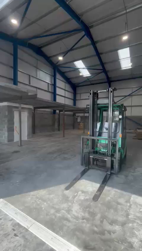 Mezzanine columns and primary steelwork in place in an empty unit with a forklift alongside